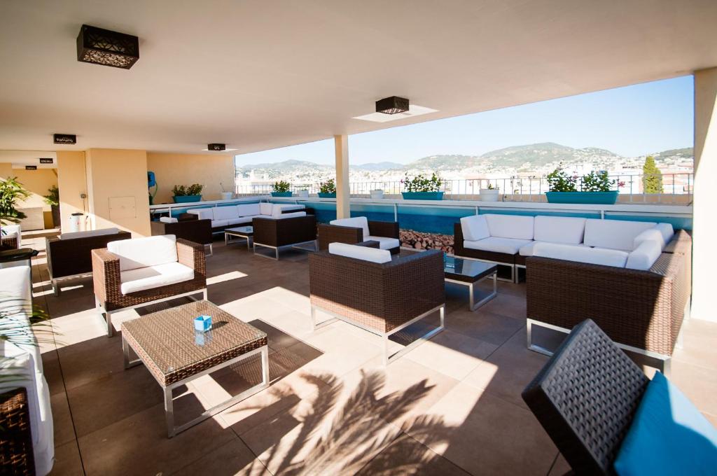 尼斯尼斯长廊公寓式酒店的天井配有沙发、椅子和桌子