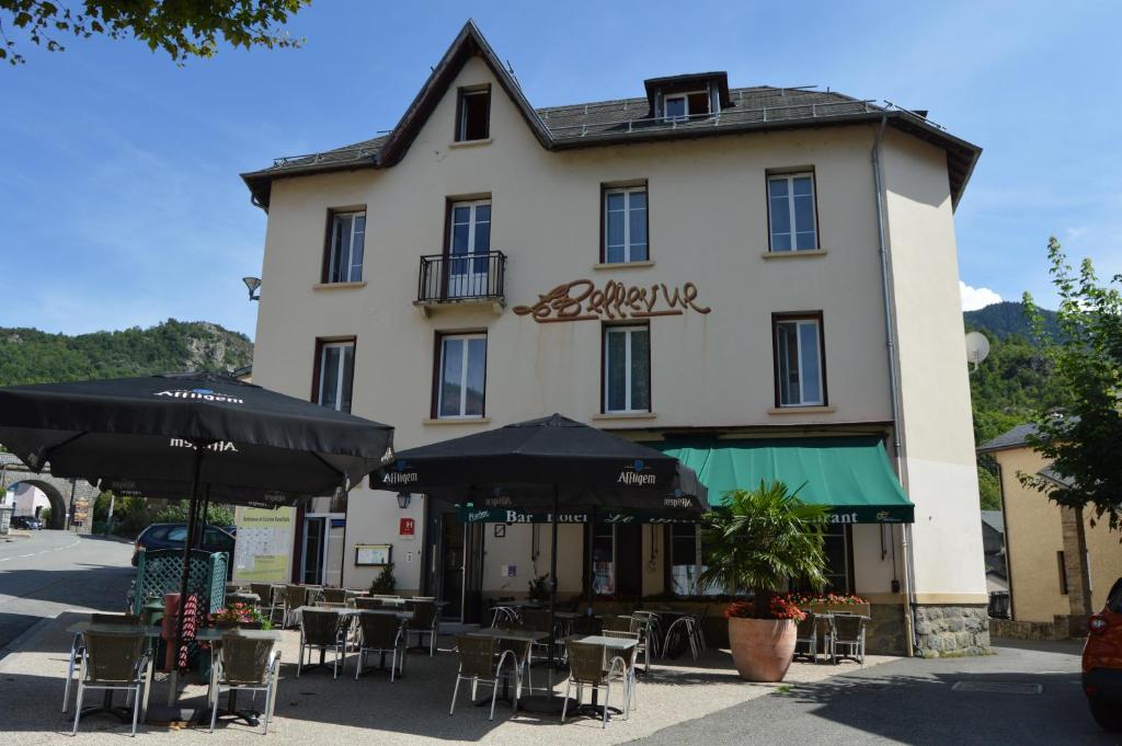 阿克斯莱泰尔姆Hôtel Restaurant Le Bellevue的前面有桌子和伞的建筑