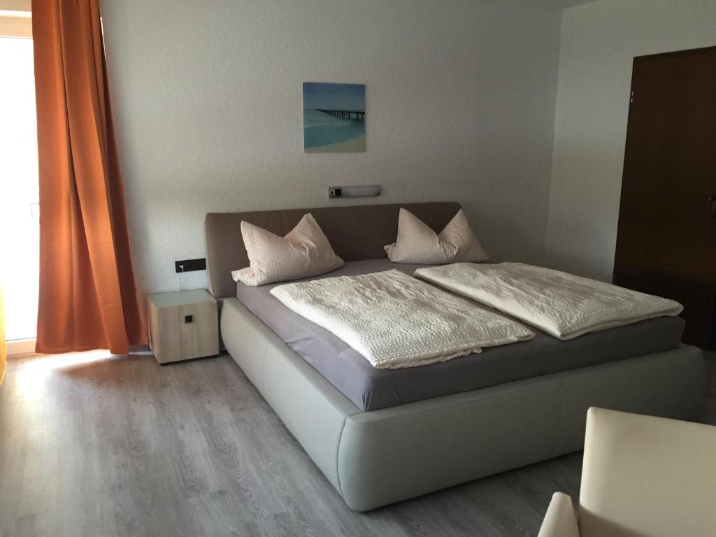 多瑙沃特Hotel M&S garni的一间卧室配有带白色床单和枕头的床。