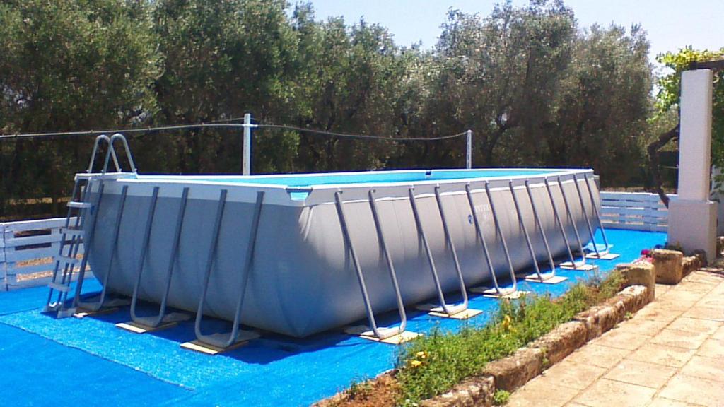 卡萨拉诺LA PILA masseria salentina con piscina 6 PL的游泳池畔蓝色的油布浴缸