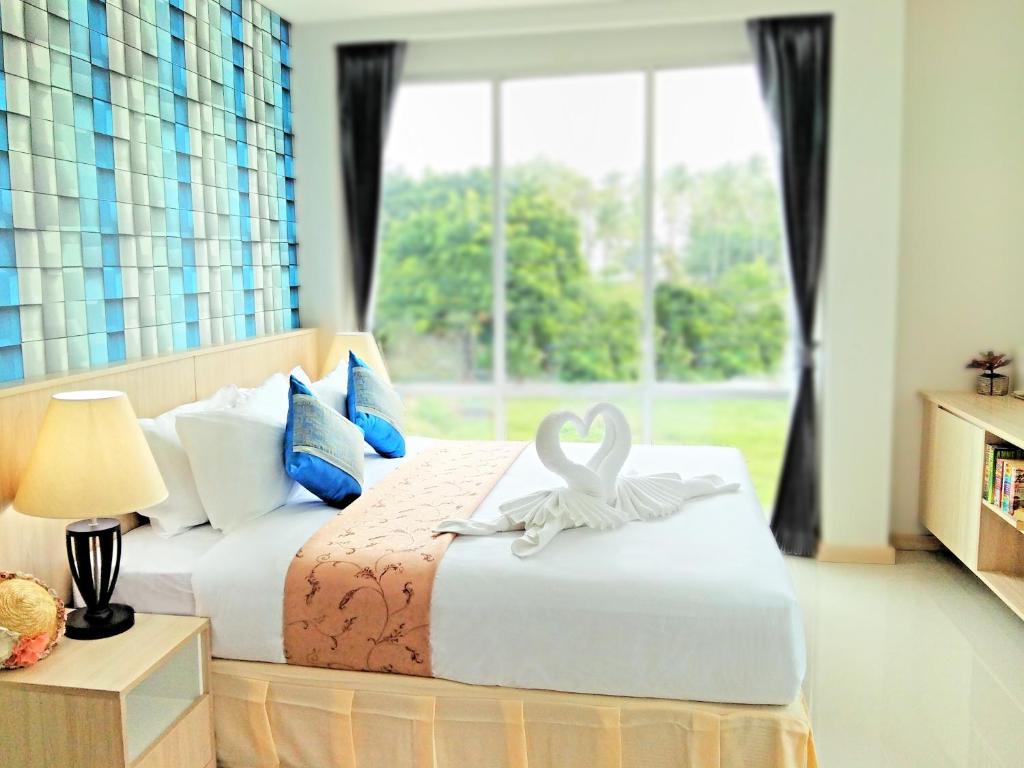 高兰The Wings Boutique Hotels Krabi Ko Lanta的一间卧室配有一张带天鹅装饰的床。