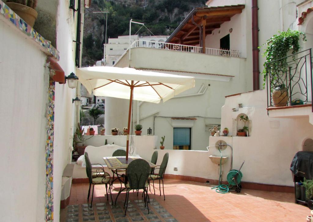 阿特拉尼弗罗拉旅馆的庭院配有桌椅和遮阳伞。