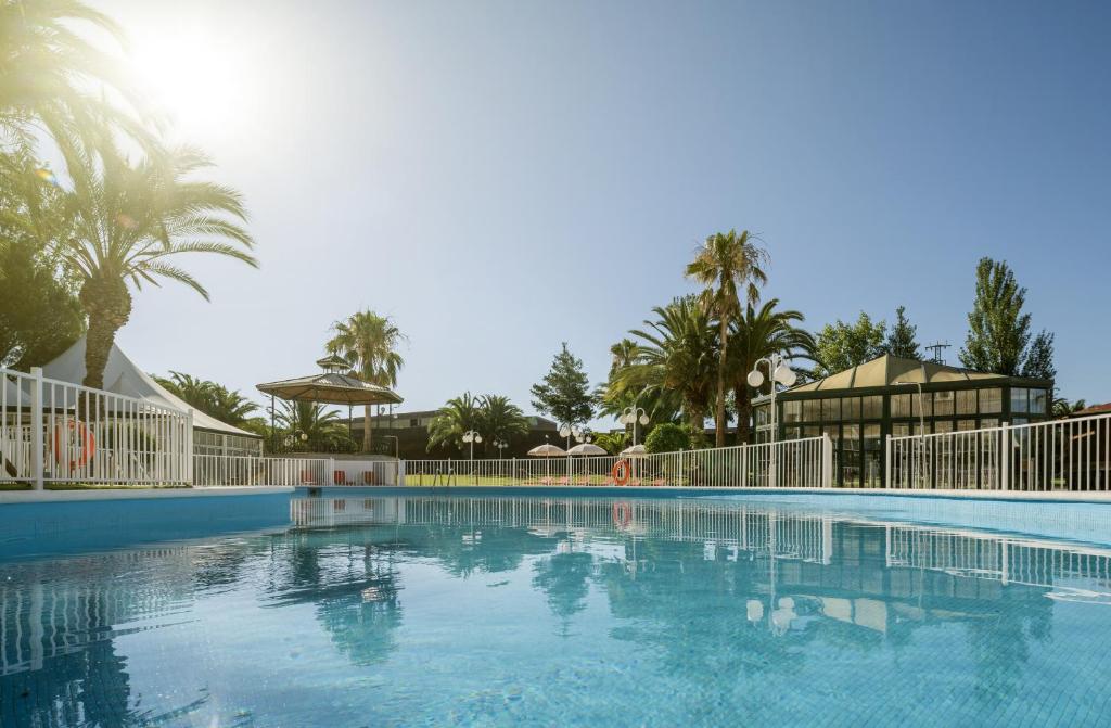 梅里达伊伦尼安拉斯洛马斯酒店的棕榈树度假村的游泳池