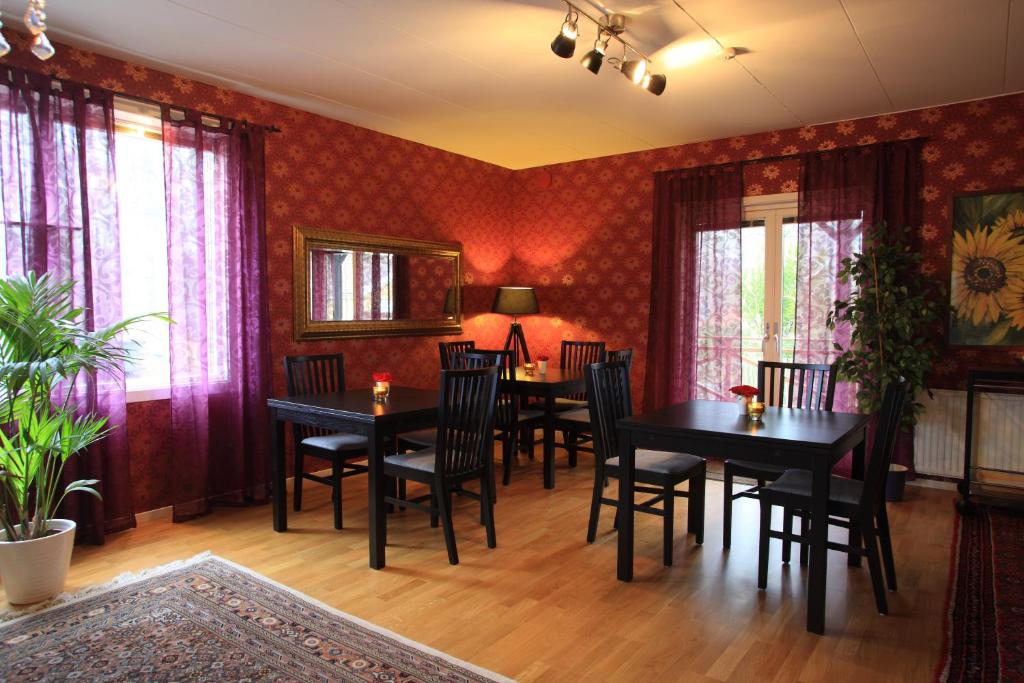 VejbystrandVejbystrands Vandrarhem的用餐室配有桌椅和红色壁纸