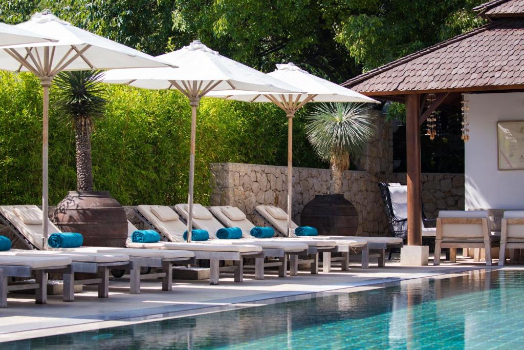 内里吉恩加尔博卡公寓的游泳池旁设有躺椅和遮阳伞的游泳池