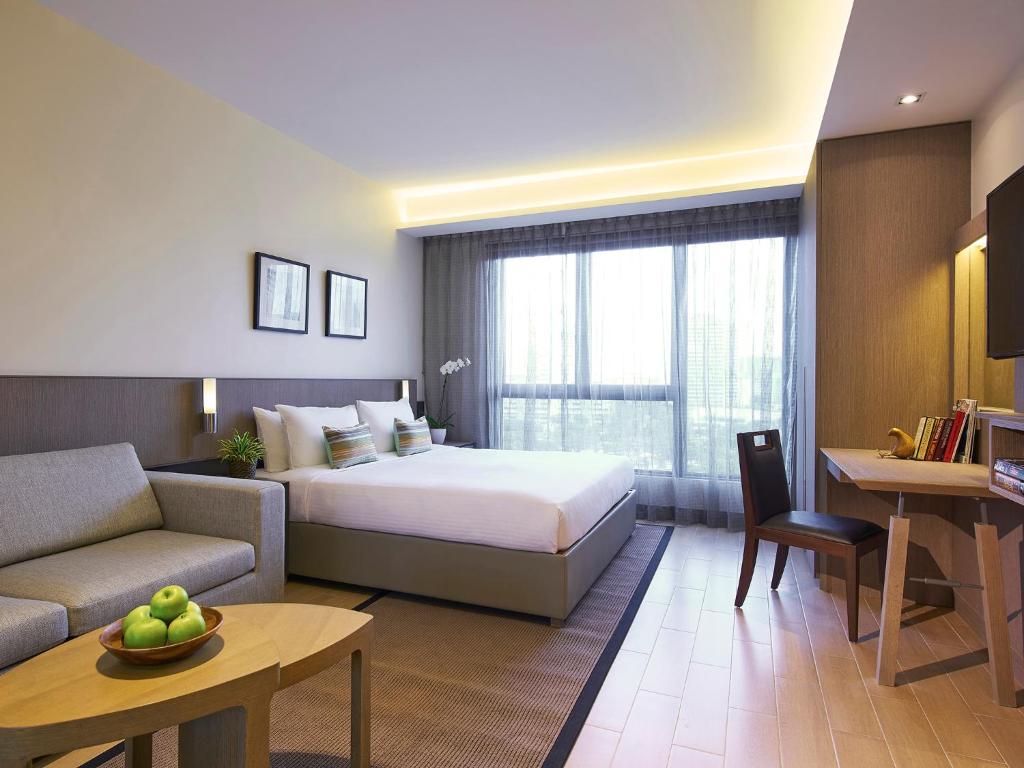 新加坡Oasia Residence Singapore by Far East Hospitality的酒店客房,配有床和沙发