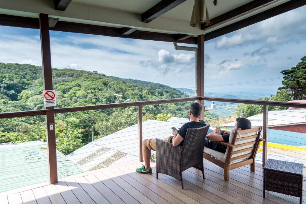 蒙泰韦尔德哥斯达黎加Camino Verde B&B Monteverde Costa Rica的一群人坐在甲板上的椅子上,欣赏美景
