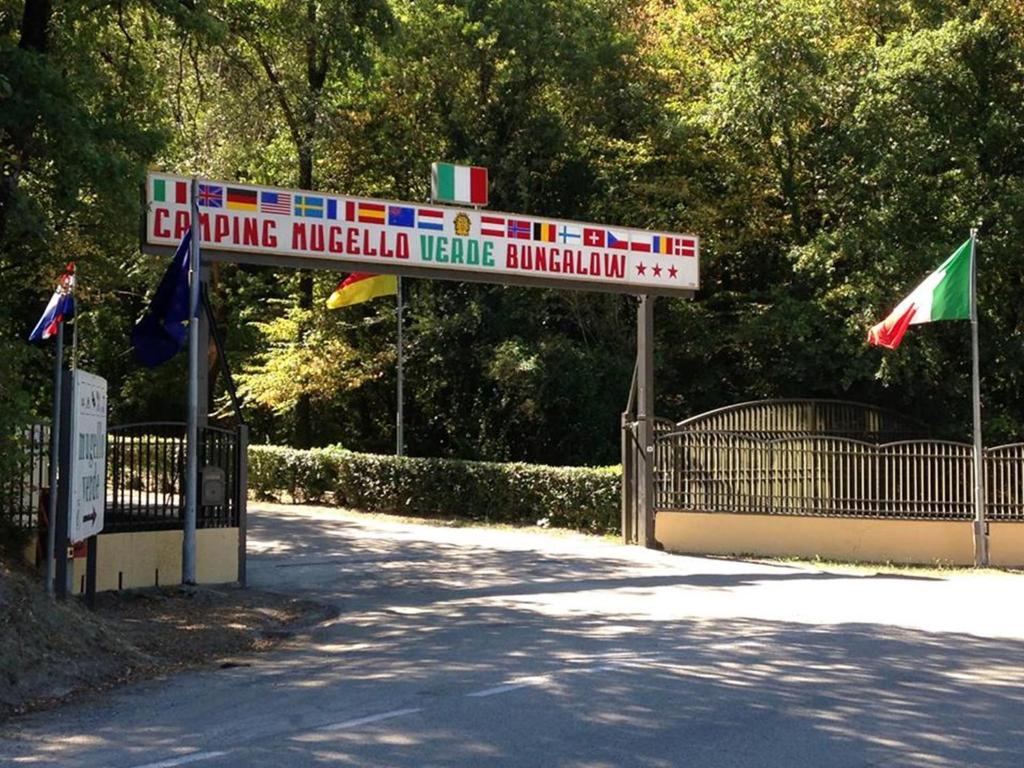 圣皮耶罗阿谢韦木吉罗维尔德营地村酒店的公园标志,在栅栏上悬挂旗帜