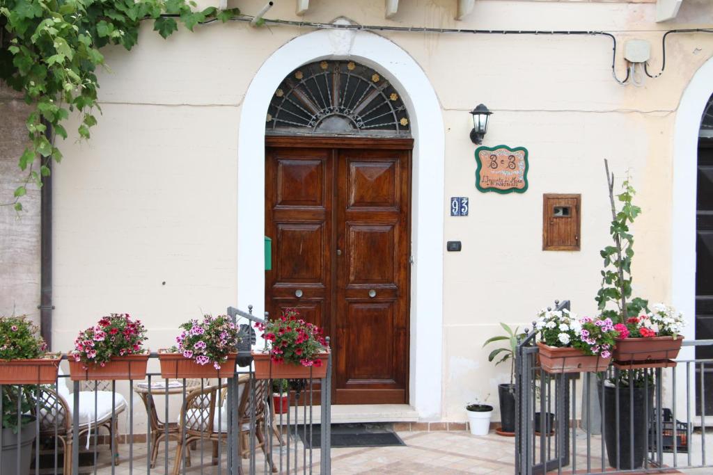 阿西亚罗利L'incanto del mare的通往带桌椅和鲜花的建筑的门