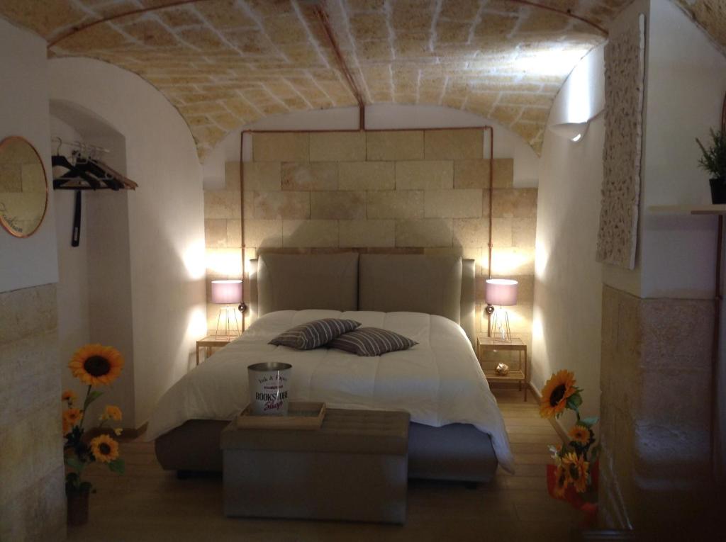 巴里Loft Piccinni nel cuore di Bari的一间卧室配有一张大床和两盏灯