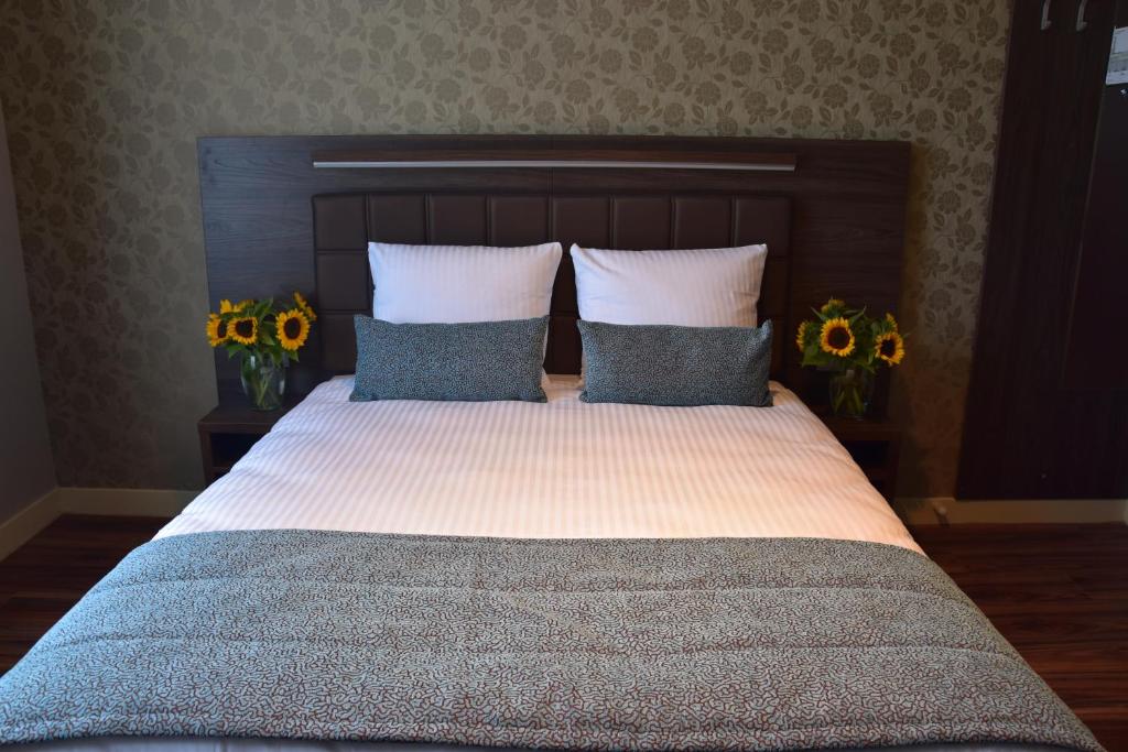 阿姆斯特丹OZO Hotels Armada Amsterdam的一间卧室配有带两个枕头和鲜花的床