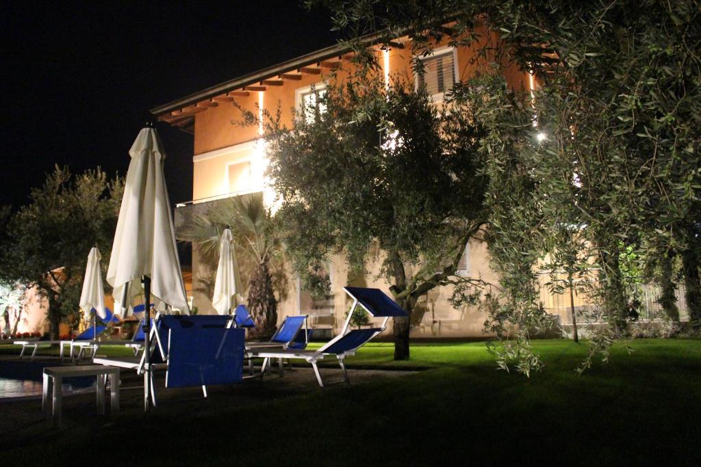 阿科Agritur il Melograno的一组椅子和遮阳伞在建筑前