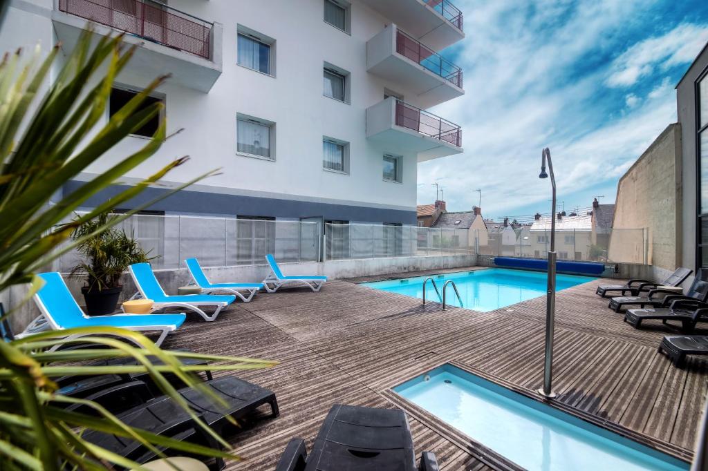 圣纳泽尔曾图德酒店 - 海洋港口公寓的一座带椅子的庭院和一座位于大楼内的游泳池