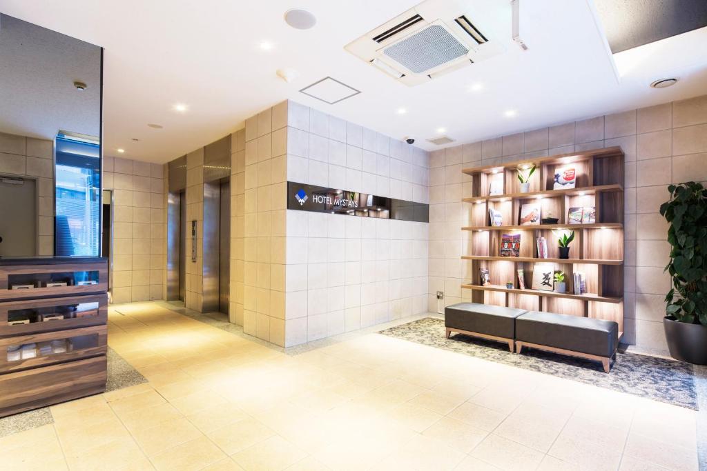 东京MYSTAYS 神田酒店的大堂设有长凳和书架