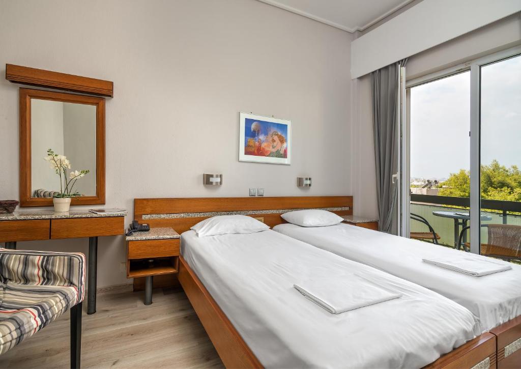 雅典公园酒店 的一间卧室设有两张床、一张桌子和一个窗口。