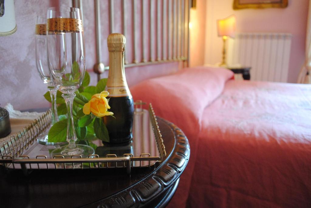 蒙雷亚莱埃尔维拉阿尔多莫酒店的睡床旁的桌子上一瓶香槟
