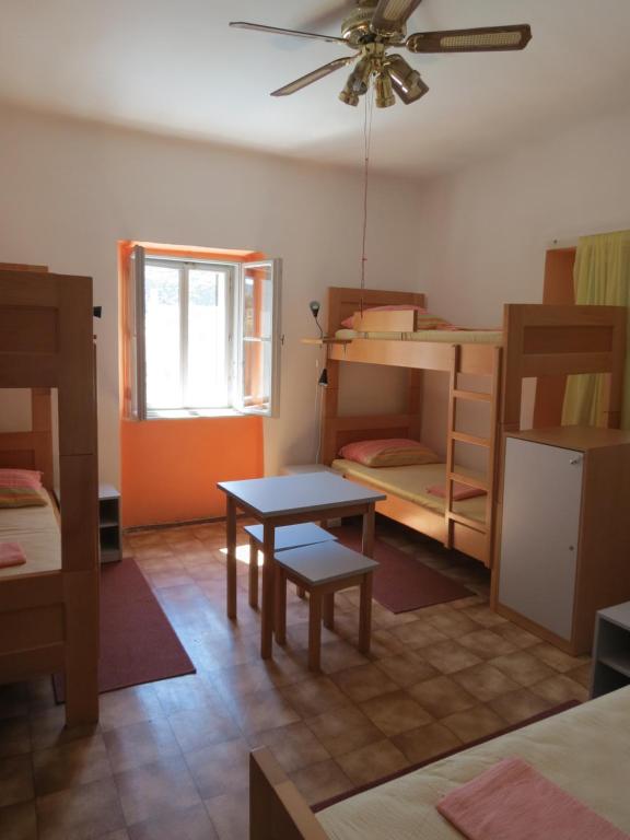大洛希尼HI Hostel Veli Losinj的客房设有桌子和一些双层床。