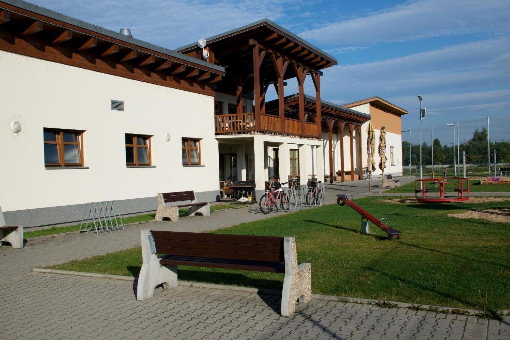 Horní PočaplySportovní areál Horní Počaply的建筑前带长凳的公园