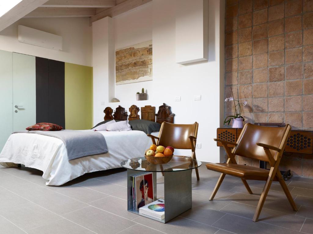 雷焦艾米利亚B&B Sottotetto的卧室配有一张床和一张桌子及椅子