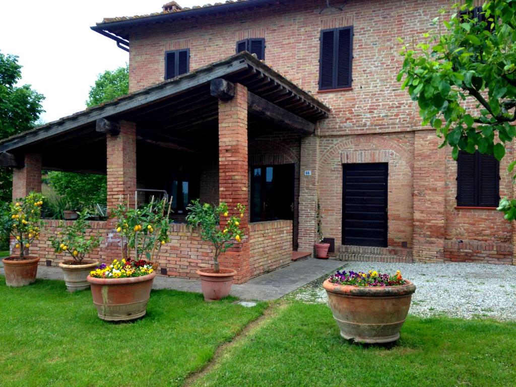 锡耶纳Lovely Tuscan Country House的砖房前的盆栽植物群
