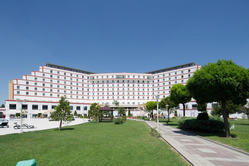 阿菲永科尔温泉度假酒店的一座大型建筑,前面有一个公园