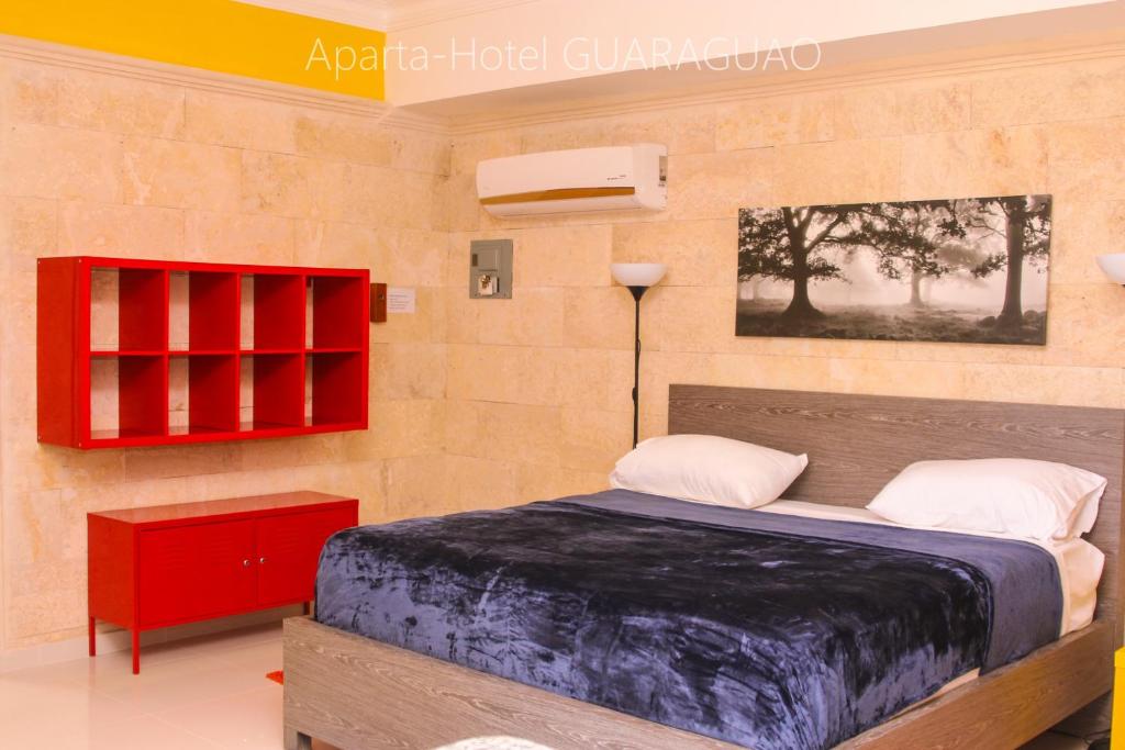 圣佩德罗-德马科里斯呱啦呱公寓式酒店的一间卧室配有一张床和一个红色橱柜
