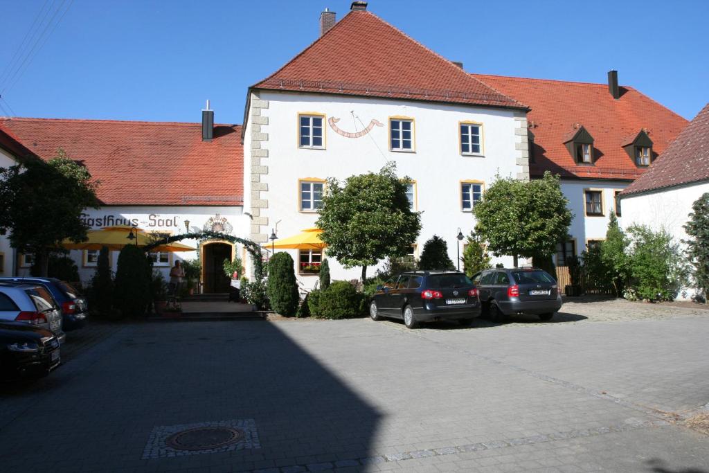 因戈尔施塔特施劳斯沃特酒店的一座白色的大建筑,汽车停在停车场
