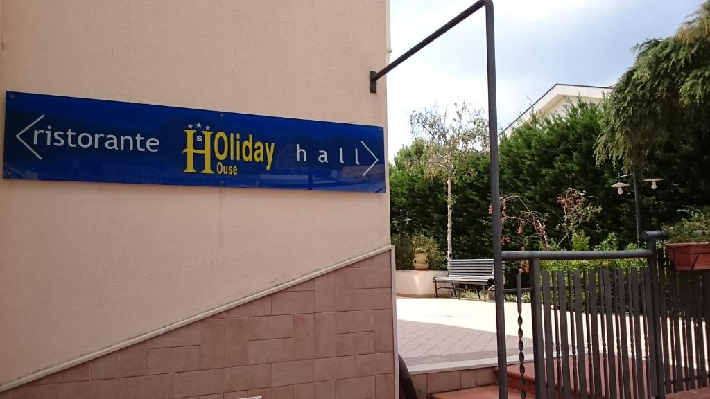圣乔瓦尼·罗通多Hotel Holiday House的建筑物一侧的蓝色标志