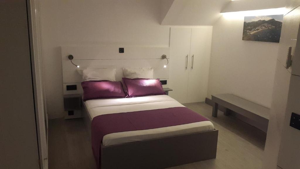 法兰西堡Studio Montgérald的一间卧室配有一张带紫色和白色枕头的床