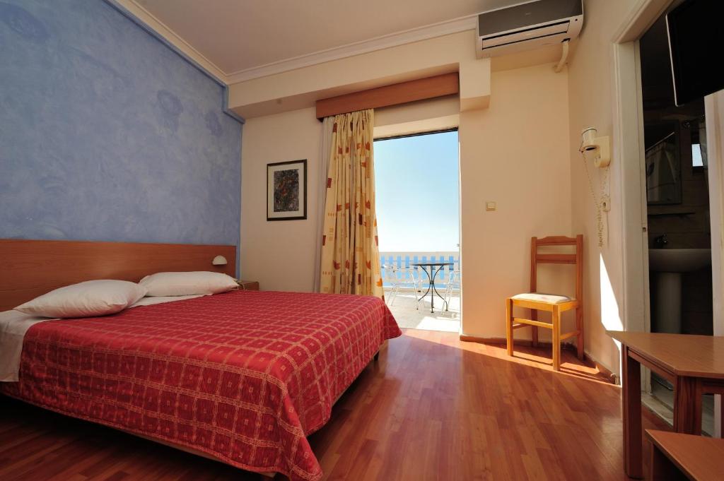 帕特雷阿多尼斯城市酒店的一间卧室配有一张床,享有海景