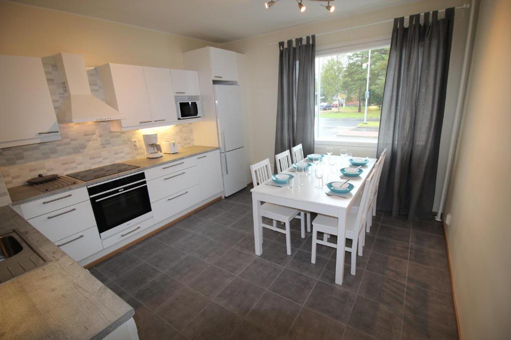 罗瓦涅米科斯基阿肯努斯公寓的厨房配有白色的桌子和白色的橱柜。