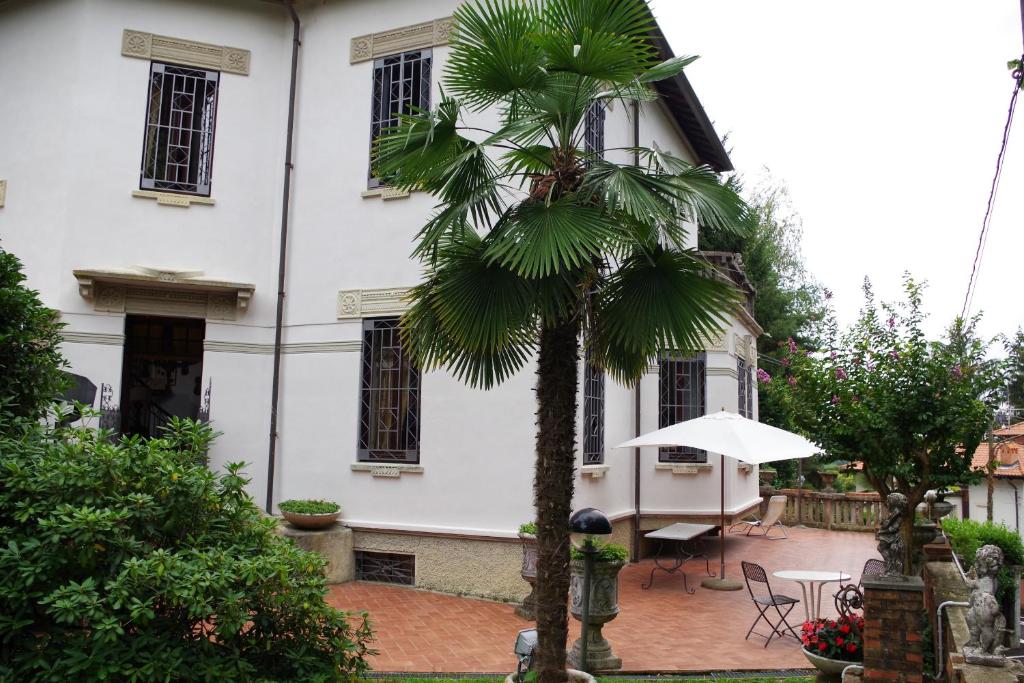 Venegono Superiore普契尼别墅度假屋的白色建筑前的棕榈树