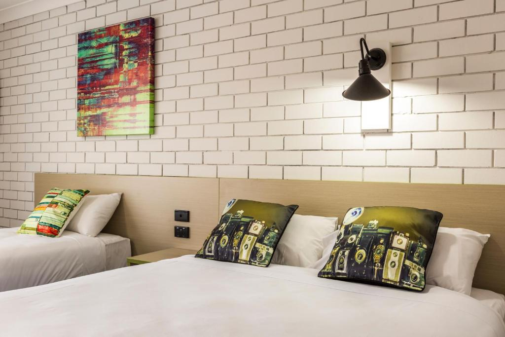 奥尔伯里回旋镖酒店的一间卧室设有两张床,墙上挂着一幅画