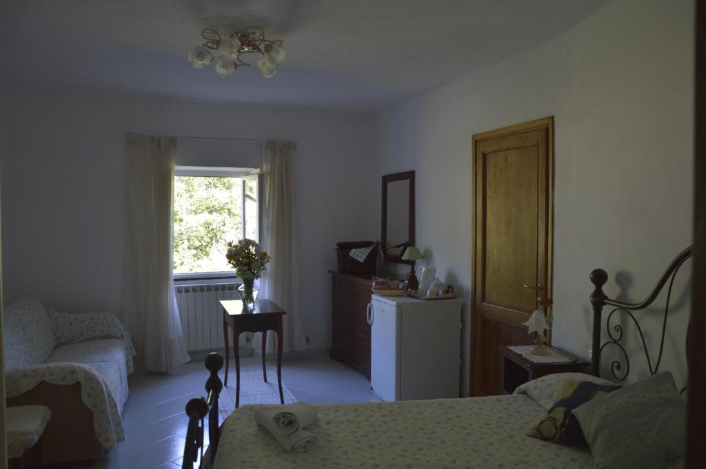莱万托Agriturismo Millefiori的卧室配有床、椅子和窗户。