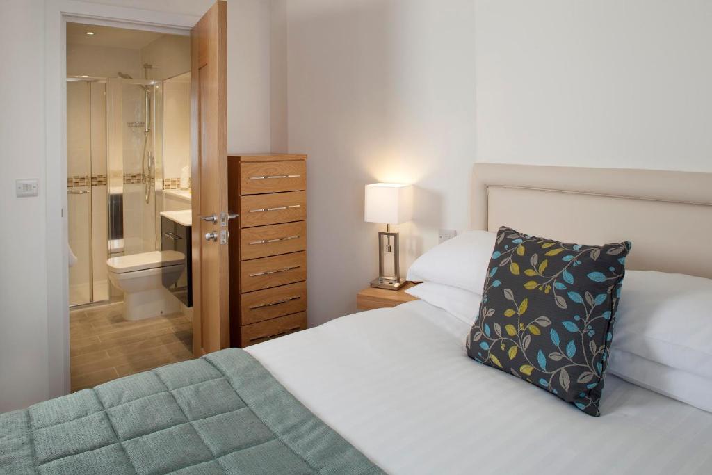 法尔茅斯Falmouth Self Catering Lodges的一间卧室配有一张床,浴室设有卫生间