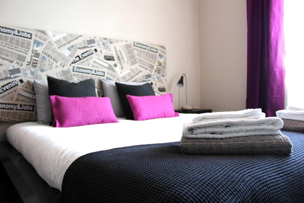 英雄港Hello Terceira的卧室配有带粉红色枕头的大型白色床
