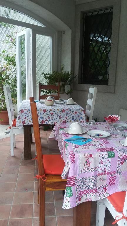 Villa Vicentina卡萨佩里尼住宿加早餐旅馆的用餐室配有带粉色和白色桌布的桌子