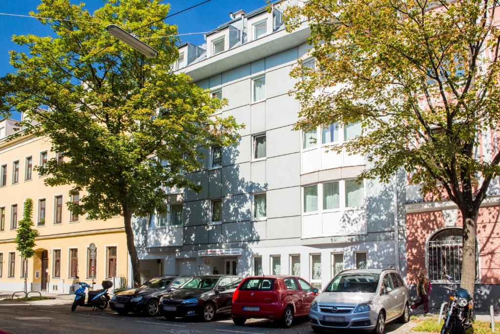 维也纳多瑙城市公寓的一座白色的建筑,前面有汽车停放