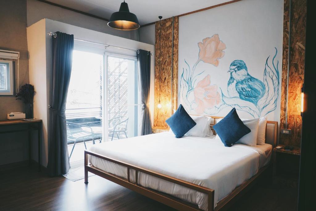 黎府独立空间公寓式酒店的卧室配有一张大床,墙上挂有绘画作品