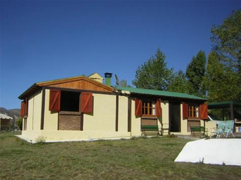 波特雷里约斯Casa Montaña Valle del Sol的田野上带绿色屋顶的小房子