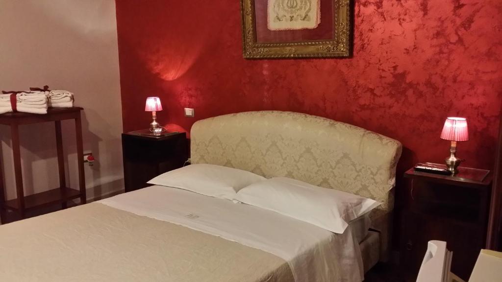 萨尔维Sorelle De Filippis的卧室配有白色的床铺和红色的墙壁