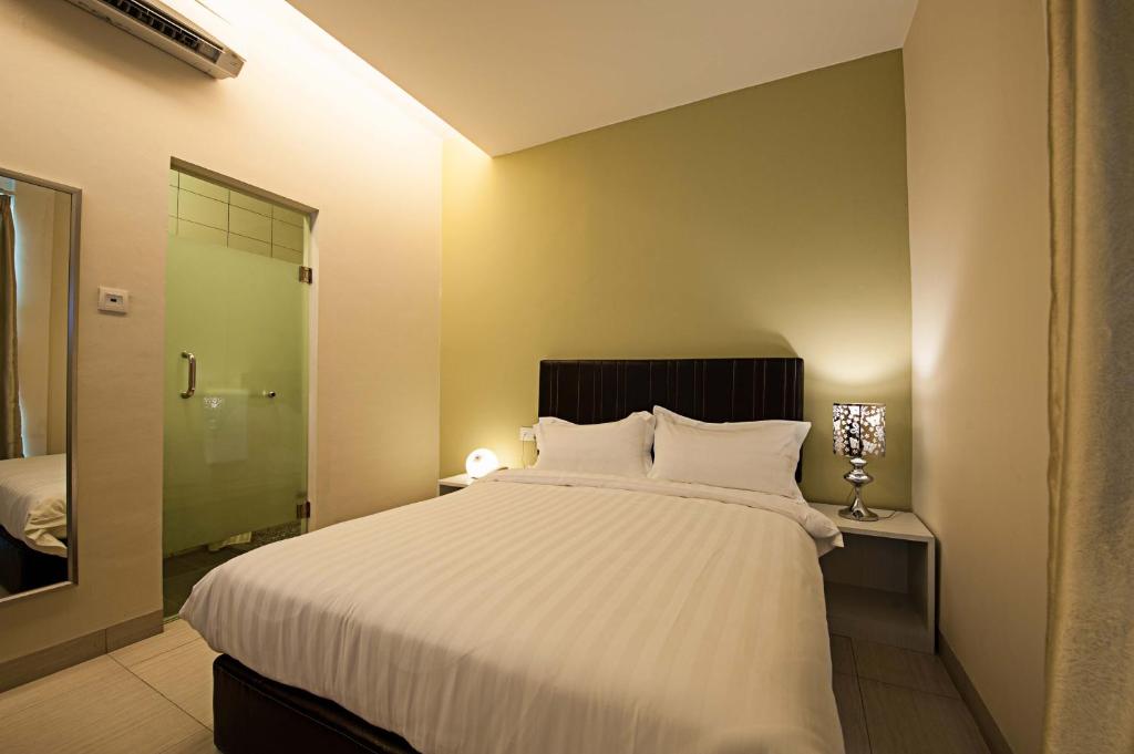 PutatanSeven Hotel的一间带白色大床的卧室和一间浴室