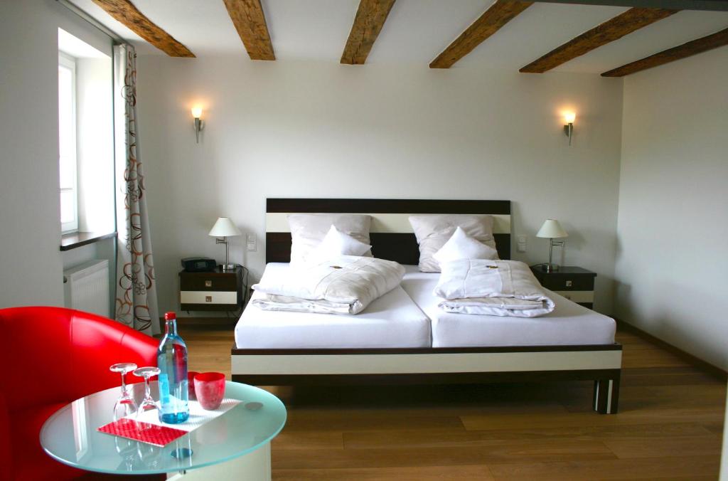 IlbesheimWein-Domizil Brennofen的一间卧室配有一张带红色椅子的床和一张桌子