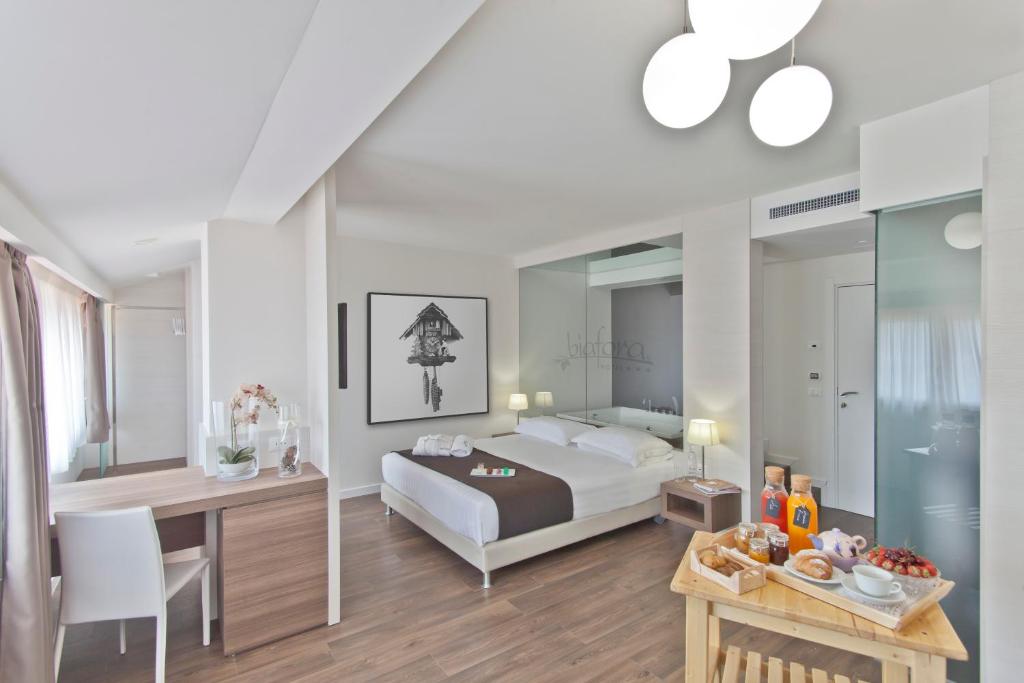 圣焦万尼因菲奥雷比夫拉Spa度假酒店的一间卧室配有一张床、一张桌子和一张桌子