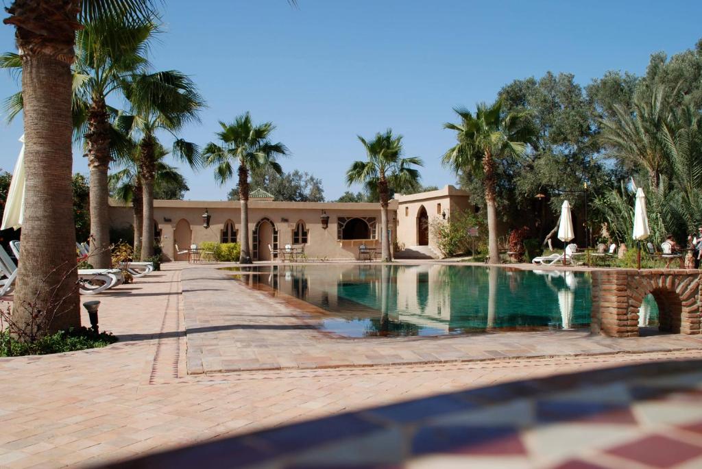 塔鲁丹特塔鲁丹特达尔基通奈酒店的一个带游泳池和棕榈树的度假村
