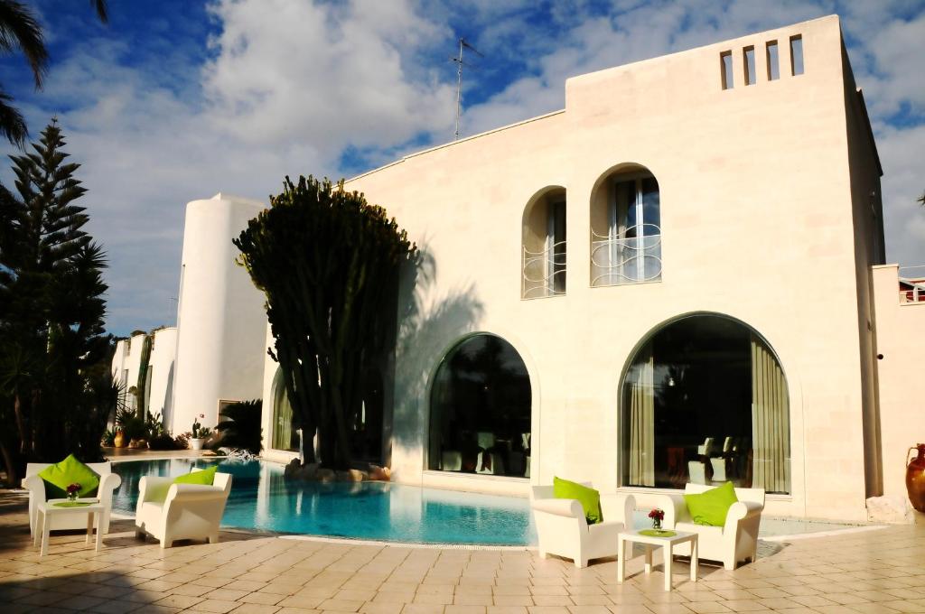 普尔萨诺伊尔格里洛酒店的一座带游泳池和椅子的度假村和一座建筑