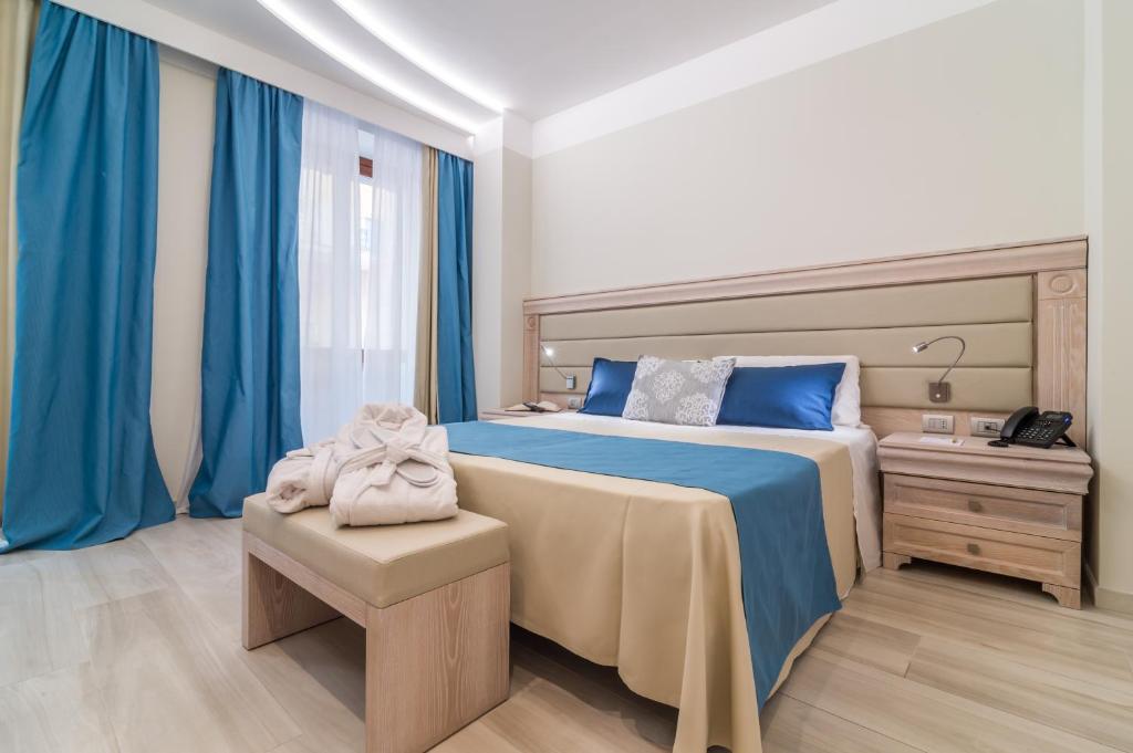 卡利亚里L'Ambasciata Hotel de Charme的一间卧室配有大床和蓝色窗帘
