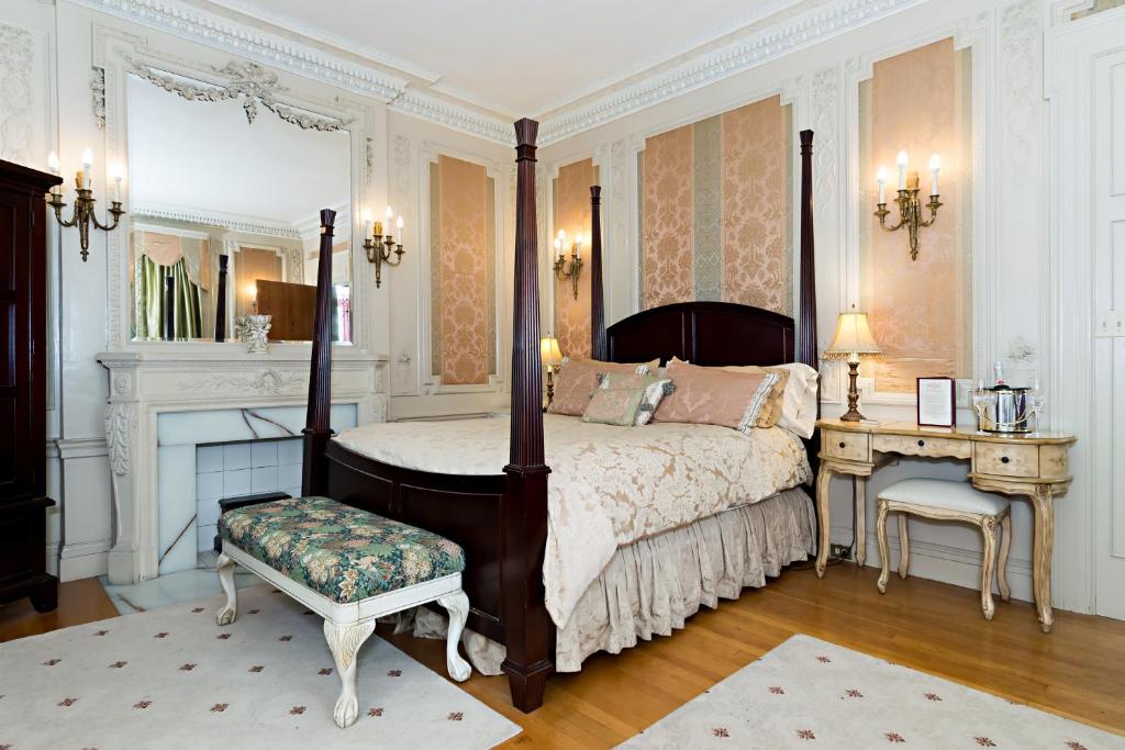 多佛银喷泉住宿加早餐旅馆的一间卧室配有一张天蓬床、一张桌子和一张四柱床。