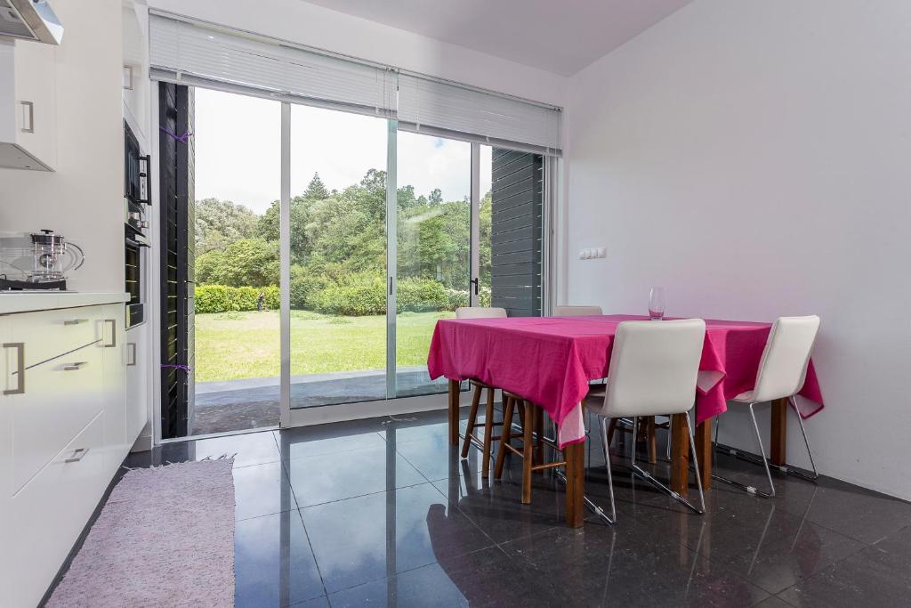 七城Casa das Camélias - Family Villa by the lagoon的用餐室配有粉红色的桌子和椅子