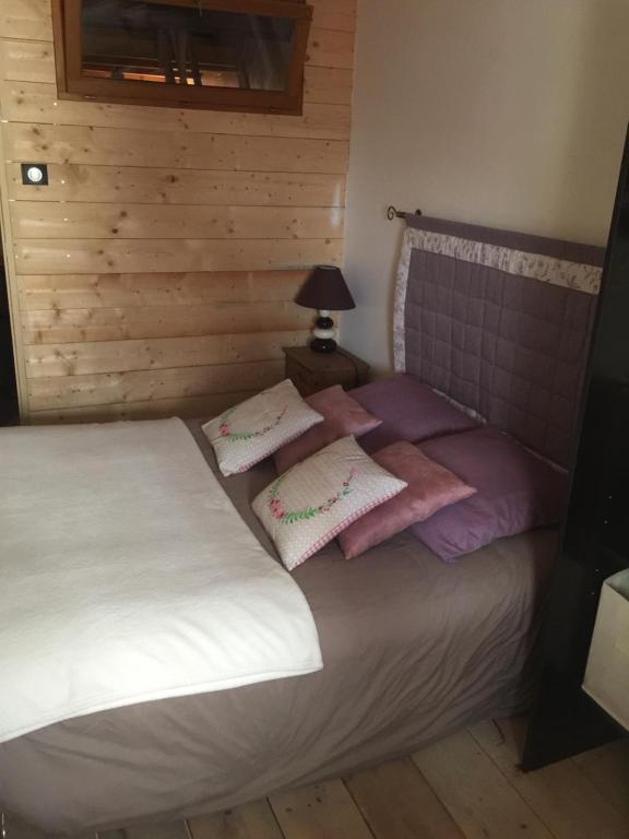 VolonneMaison La Minoterie的一间卧室配有带粉色和白色枕头的床